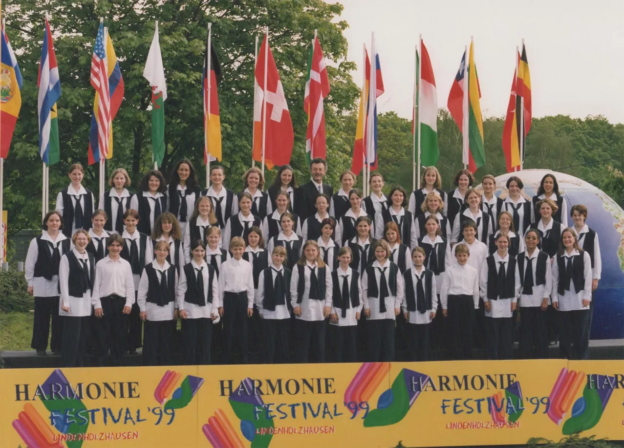 Chor in schwarz-weißer Kleidung vor internationalen Flaggen beim Harmonie Festival '99 in Lindenholzhausen