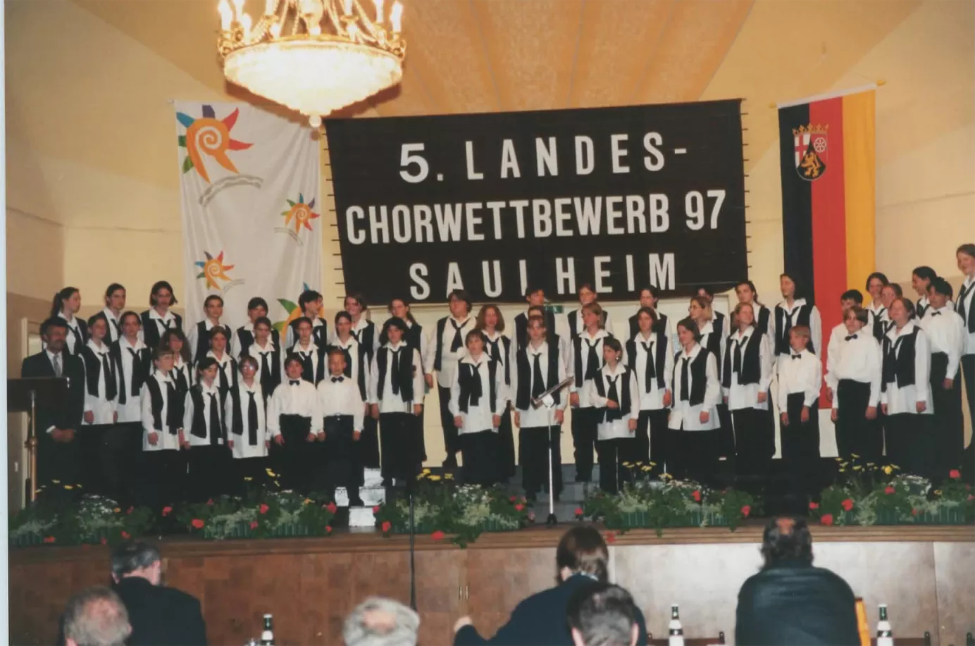 Auftritt beim 5. Landes-Chorwettbewerb 1997 in Saulheim vor großem Wettbewerbsbanner