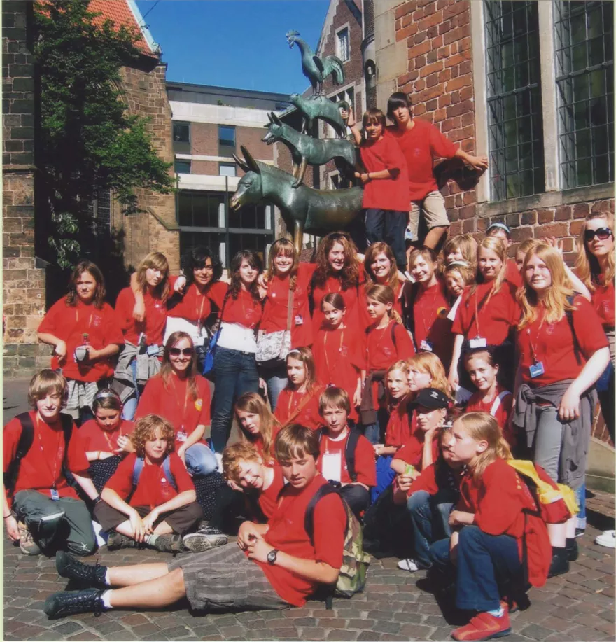 Chor in roten Shirts vor der Bremer-Stadtmusikanten-Statue beim Chorfest in Bremen