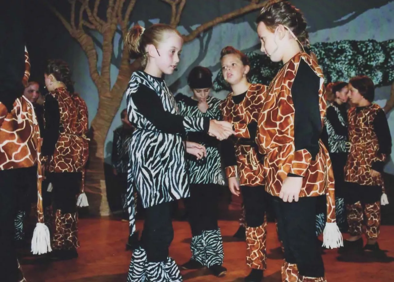 Kinder in Giraffen- und Zebra-Kostümen auf der Bühne beim Musical Tushi Pamoja