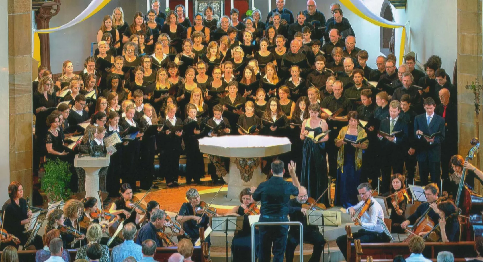 Konzert der Südpfalz Lerchen mit großem Chor, Orchester und Dirigent in einer historischen Kirche