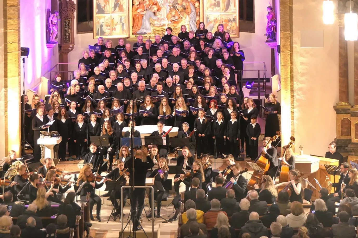 Großer Chor mit Orchester und Dirigent vor dem Altar bei der Aufführung des Herxheimer Te Deum