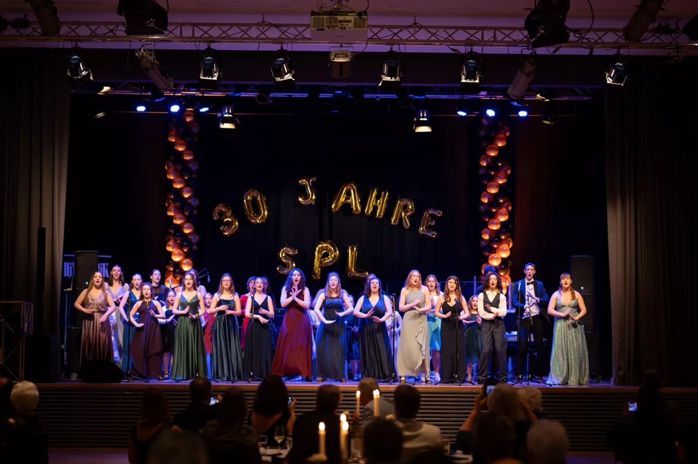 Chor in festlicher Abendgarderobe singt unter dem Ballon-Schriftzug 30 Jahre SPL beim Jubiläumsball