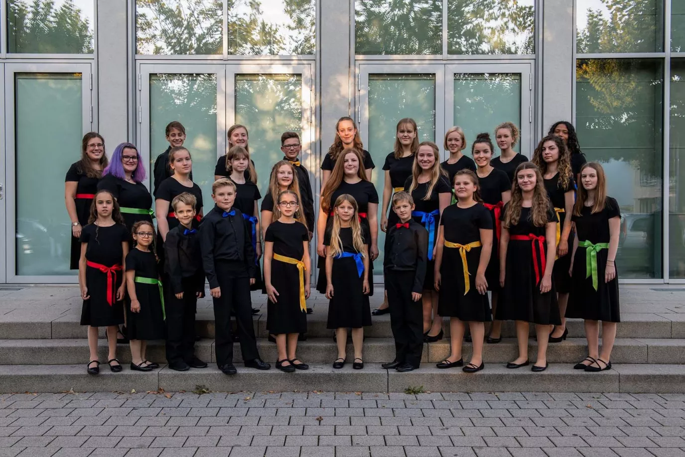 Offizielles Gruppenfoto des Chors in neuer schwarzer Chorkleidung mit farbigen Schärpen
